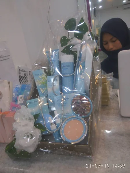 Siyah eldivenli bir adam bir fincan kahve tutuyor ve pencere eşiğinde oturuyor.