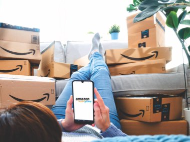 Almanya, Rostock - 13 Haziran 2021: Amazon Prime paketleri. Amazon Prime Day 'de internetten alışveriş yapan bir kadın. Mesafe, ev ve online alışveriş