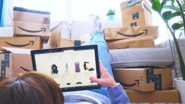 Almanya, Rostock - 13 Haziran 2021: Amazon Prime paketleri. Amazon Prime Day 'de internetten alışveriş yapan bir kadın. Mesafe, ev ve online alışveriş