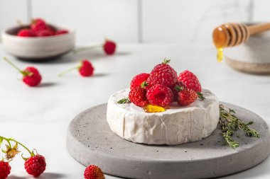 Taze böğürtlenli camembert peyniri, bal ve beyaz arka planda kekik. Sağlıklı atıştırmalıklar. Fransız mezesi.