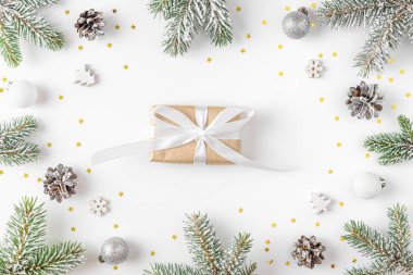 Noel ya da Mutlu Yıllar geçmişi. Köknar ağacı dallarından yapılmış bir çerçevede hediye kutusu, beyaz arka planda tatil süslemeleri. Düz yatıyordu. Üst görünüm