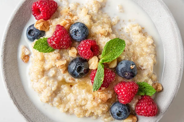 Quinoa Porridge Fresh Berries Nuts Honey Mint Bowl White Background — Stock Photo, Image