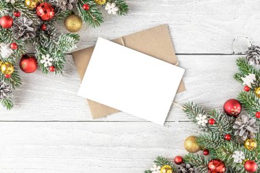 Noel ya da köknar ağacıyla yeni yıl tebrik kartı, beyaz ahşap arka planda tatil süslemeleri. Düz yatıyordu. Model yap. Üst Manzara. Bayram davetiyesi.