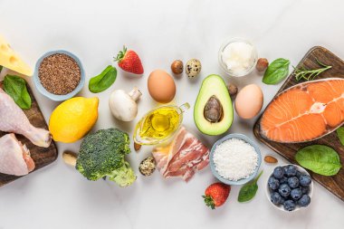 Ketojenik, keto, düşük karbonhidrat diyeti. Sebzeler, et, balık, fındık, peynir, böğürtlen, beyaz arka planda yağ. Üst Manzara. Sağlıklı gıda konsepti