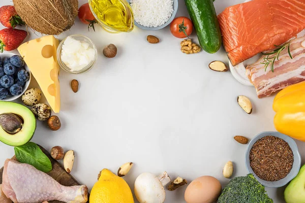 Ketojenik, keto, düşük karbonhidrat diyeti. Sebze, et, balık, fındık ve yağdan yapılmış çerçeve beyaz arka planda. Üst Manzara. Sağlıklı gıda konsepti