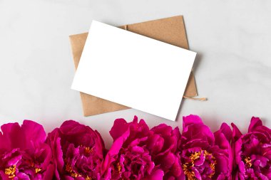 Beyaz arka planda pembe şakayık çiçekleri olan boş bir tebrik kartı. Düğün davetiyesi. Model yap. Düz yatıyordu. Neşeli arkaplan