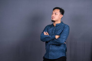 Kendine güveni tam bir Asyalı 'nın portresi. Olumlu, neşeli duygular hisset. Gerçek bir profesyonel uzman, gri arka planda izole edilmiş günlük kıyafetler giyer.