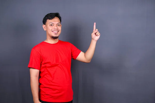 Asiatisk Ung Man Röd Shirt Pekar Med Fingret Isolerat Grå — Stockfoto