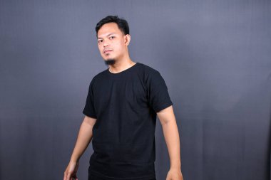 Gri arka planda izole edilmiş ve savaşmaya hazır Asyalı bir adamın portresi.