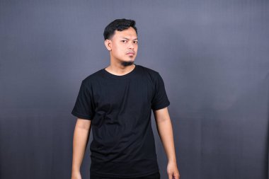 Gri arka planda izole edilmiş ve savaşmaya hazır Asyalı bir adamın portresi.