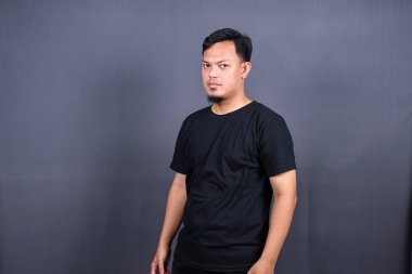 Gri arka planda izole edilmiş ve savaşmaya hazır Asyalı bir adamın portresi.