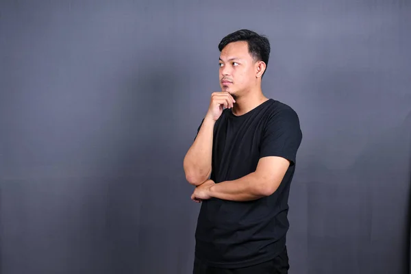 Asyalı Genç Adam Siyah Tişört Giyip Bir Şeyler Düşünüyor Zole — Stok fotoğraf