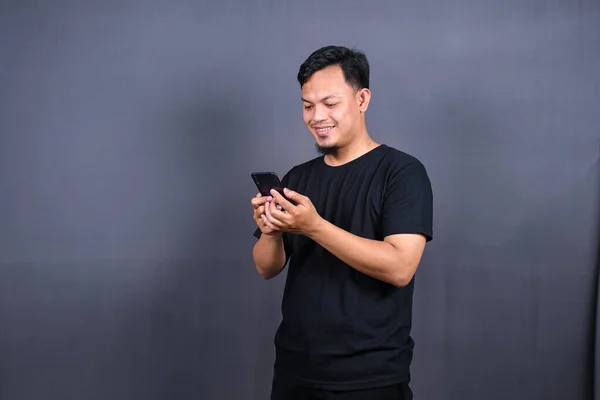Φωτογραφία Από Ελκυστικό Ασιατικό Τύπο Κρατώντας Κινητό Τηλέφωνο Φορούν Μαύρο — Φωτογραφία Αρχείου