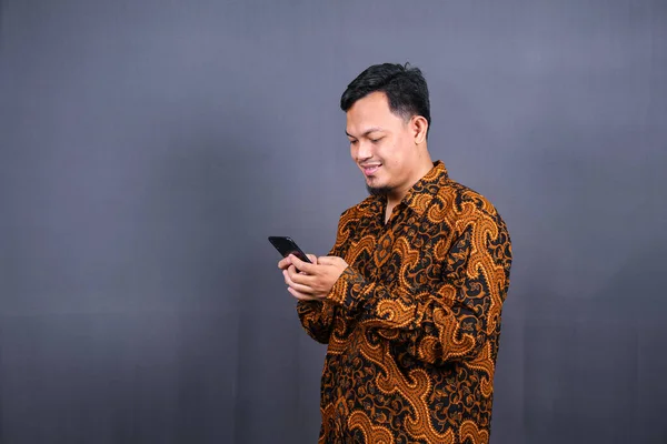 Retrato Hombre Joven Asiático Usando Batik Usando Teléfono Celular Sobre —  Fotos de Stock