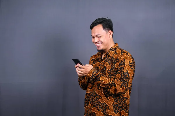 Ritratto Giovane Asiatico Che Indossa Batik Usando Cellulare Sfondo Grigio — Foto Stock