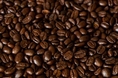 Kahverengi kavrulmuş kahve çekirdekleri yakın plan karanlık arka planda. Yüksek kalite fotoğraf