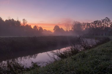 Belçika 'da Nete Nehri' nde sisli bir sabahta gün doğumu. Aydınlık ve soğuk bir Kasım sabahıydı, nehrin üzerinde biraz sis vardı..