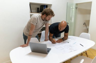 Stüdyolarında bir proje üzerinde çalışan iki genç mimar. Yeni bir müşterileri var ve ona yeni evi teklif etmek için birlikte çalışıyorlar..