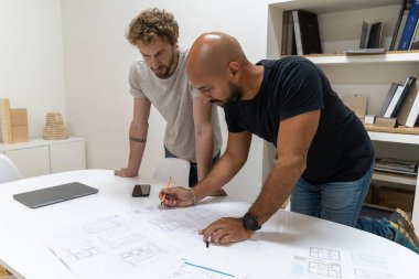 Stüdyolarında bir proje üzerinde çalışan iki genç mimar. Yeni bir müşterileri var ve ona yeni evi teklif etmek için birlikte çalışıyorlar..