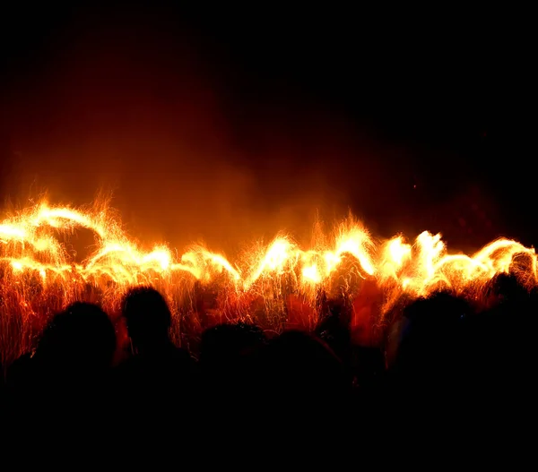 People enjoying under the fire dance in the darkness