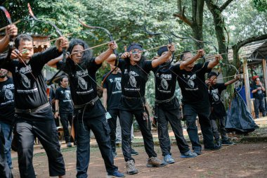 Okçuluk yarışması düzenleyen bir grup insan.