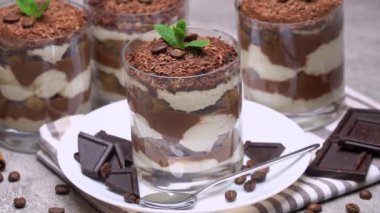 Tahta arka planda çikolata ve nane yapraklı tiramisu tatlısı. seçici odak.