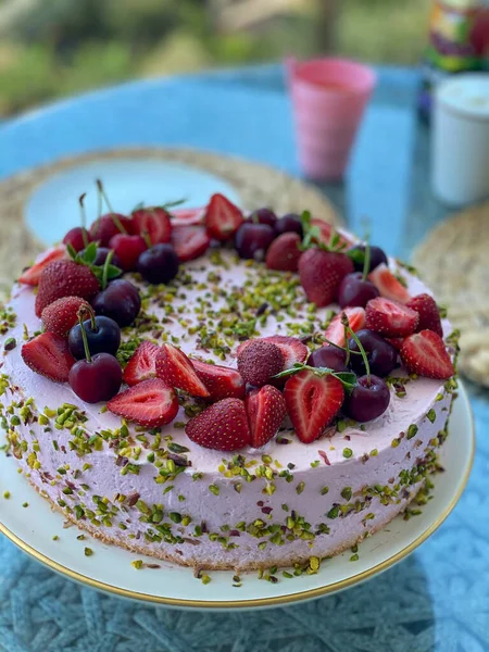 Homemade cake decorated with strawberries and cherries