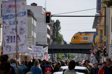 Berlin Almanya 23.9.2022, göstericiler şu tabelayı taşıyor: Berlin sokaklarında 2022 küresel iklim grevinde, trenin ve kırmızı trafik ışığının önünde paylaşım tasarruf ediyor.