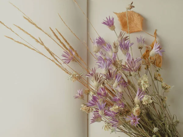 a bouquet of field dried flowers on a blank page of a notebook