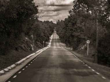 Yerden gökyüzüne uzanan sonsuz yol bulutlarla dolu. Siyah ve beyaz.