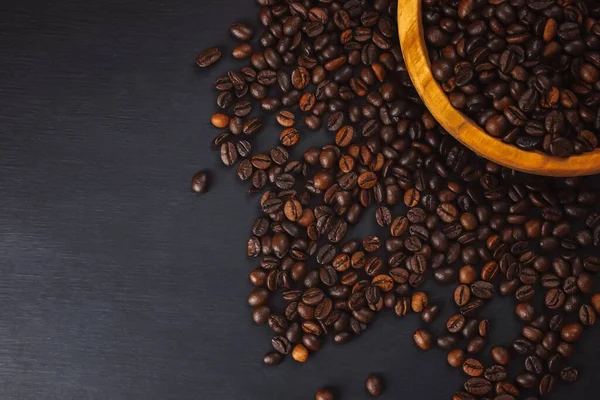 コーヒー豆の食感やコーヒー豆の背景 焙煎したコーヒー豆 コーヒー豆のショットを閉じます コーヒー豆が多い コーヒー豆は背景として使うことができます 新鮮な焙煎コーヒー豆 コーヒー豆を木のスプーンで — ストック写真