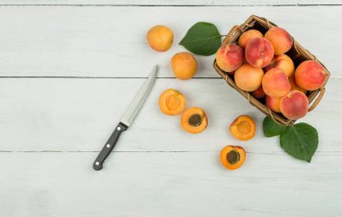 Kırsal arka planda olgun kayısılar. Ahşap arka planda yaprakları olan kayısılar. Metin için kopyalama alanı olan olgun kayısılar. Çeşitli taze yaz meyveleri. Ahşap bir masada kayısılar. Üst görünüm.