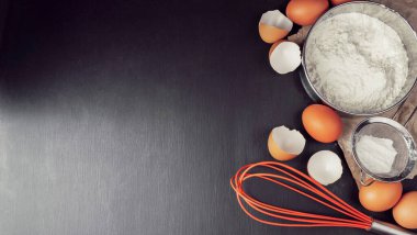 Zencefilli ekmek: un, yumurta, mutfak aletleri, kap kacak ve koyu ahşap masa. Üst Manzara. Düz yatış stili. Model yap. Noel pastası.