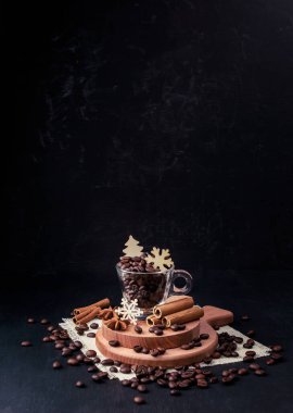 Sıcak aromalı kahve bardağı. Kış tatili konsepti. Kahve ve kar taneleri, kozalaklar ve baharatlar. Tarçın ve yıldız anason. Kahveyi ve kış soğuğunda ev huzurunu seviyorum. Hygge..