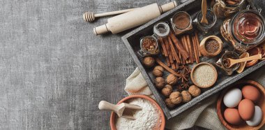 Aşk pişirmek. Fırın geçmişi. Siyah arka planda yemek malzemeleri ve mutfak aletleri var. Un, badem fıstığı, yumurta. Üst Manzara. Modern yemek kompozisyonu. Baharatlar ve gıda ürünleri.