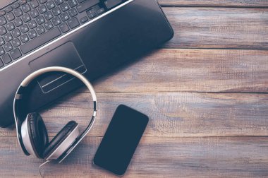 Ofis masasının dizüstü bilgisayarlı, akıllı telefonlu fotokopi arkaplanlı düz bir fotoğrafı. Müzik stüdyosu ya da kayıt stüdyosu. Model.