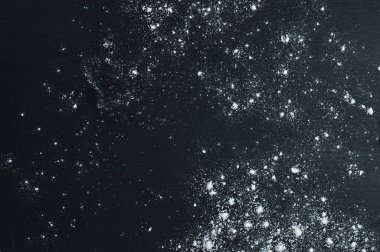 Sırt desenli bir masaya serpiştirilmiş beyaz buğday ununun düz kompozisyonu ve metin için boş bir yer. Soyut arkaplan. Yemek pişirme, fırın veya pastane kavramı.