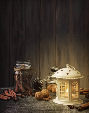 Noel feneri sahnesi. Mutlu Noeller tebrik kartı. Karanlık ahşap arka planda süslemeleri olan Noel feneri. Kış mevsimi. Arka planda şenlikli ışıklar ve metin için yer var.. 