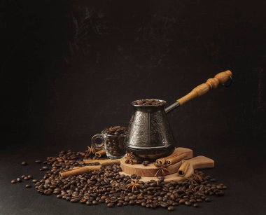Kavrulmuş kahve çekirdekleri, baharatlar ve Türk (cezve). Tarçınlı Türk kahvesi ve anason kompozisyonu. Tarçın çubukları ve anason yıldızları kavrulmuş kahve çekirdekleri üzerinde baharatlar..