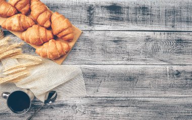 Kruvasanlı kahve. Kahvaltıda. Ayrıl. Taze fırın. Ev yapımı tahıllı kruvasan. Kahve dükkanı konsepti, geleneksel kahvaltı, sabah ayini. Bir fincan kahve..