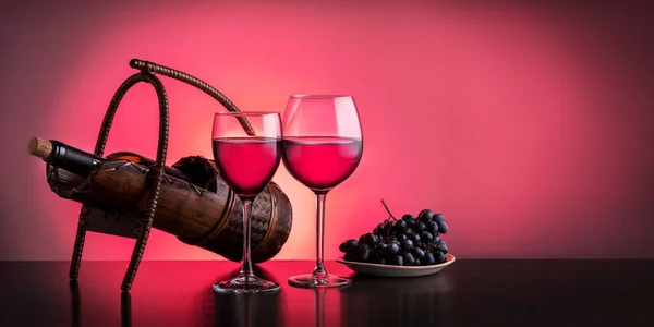 红酒倒入两杯 葡萄倒入盘中 放在深色木桌上 — 图库照片