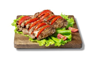 Tahta üzerinde kırmızı biber bulunan domuz eti dilimleri beyaza izole edilmiş..