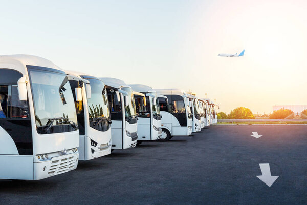  Buses at the parking in the airport at sunrise. Summer travel, tourism and vacation concept.