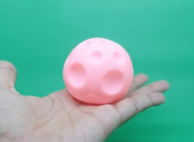 Renkli bebek çıngırakları ya da bağcıkları yeşil arka planda izole edilmiş, bebek dişlerinin büyümesini teşvik etmek için..