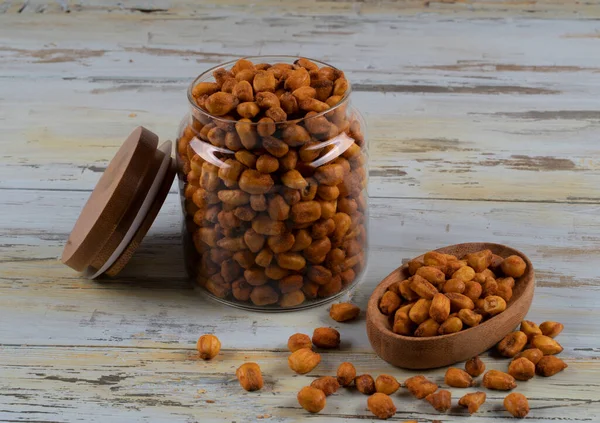 Roasted corn nuts in a glass jar and roasted corns in a wooden plate