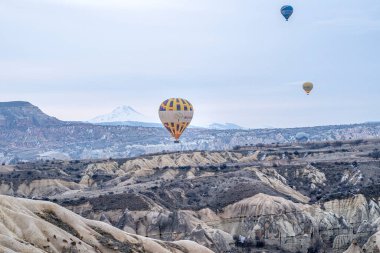 Türkiye 'nin başkenti Kapadokya' daki dağ manzarası üzerinde uçan sıcak hava balonlarının (atmosfer balonları) sabah başlangıcı