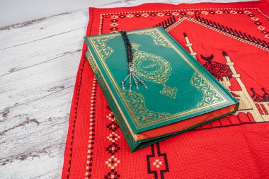 El yapımı kırmızı halıya Kur 'an ve tespih. Ramazan kutsanmıştır..