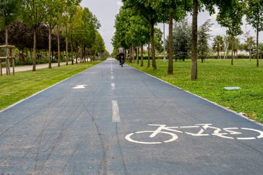 Parktaki bisiklet yolu. Kaldırımdaki bisiklet ve dikkat yollarının sembolü.