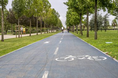Parktaki bisiklet yolu. Kaldırımdaki bisiklet ve dikkat yollarının sembolü.