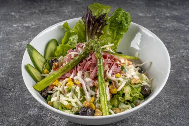 Sebzeli yeşil salata, zeytin, peynir, salam ve kuşkonmaz..